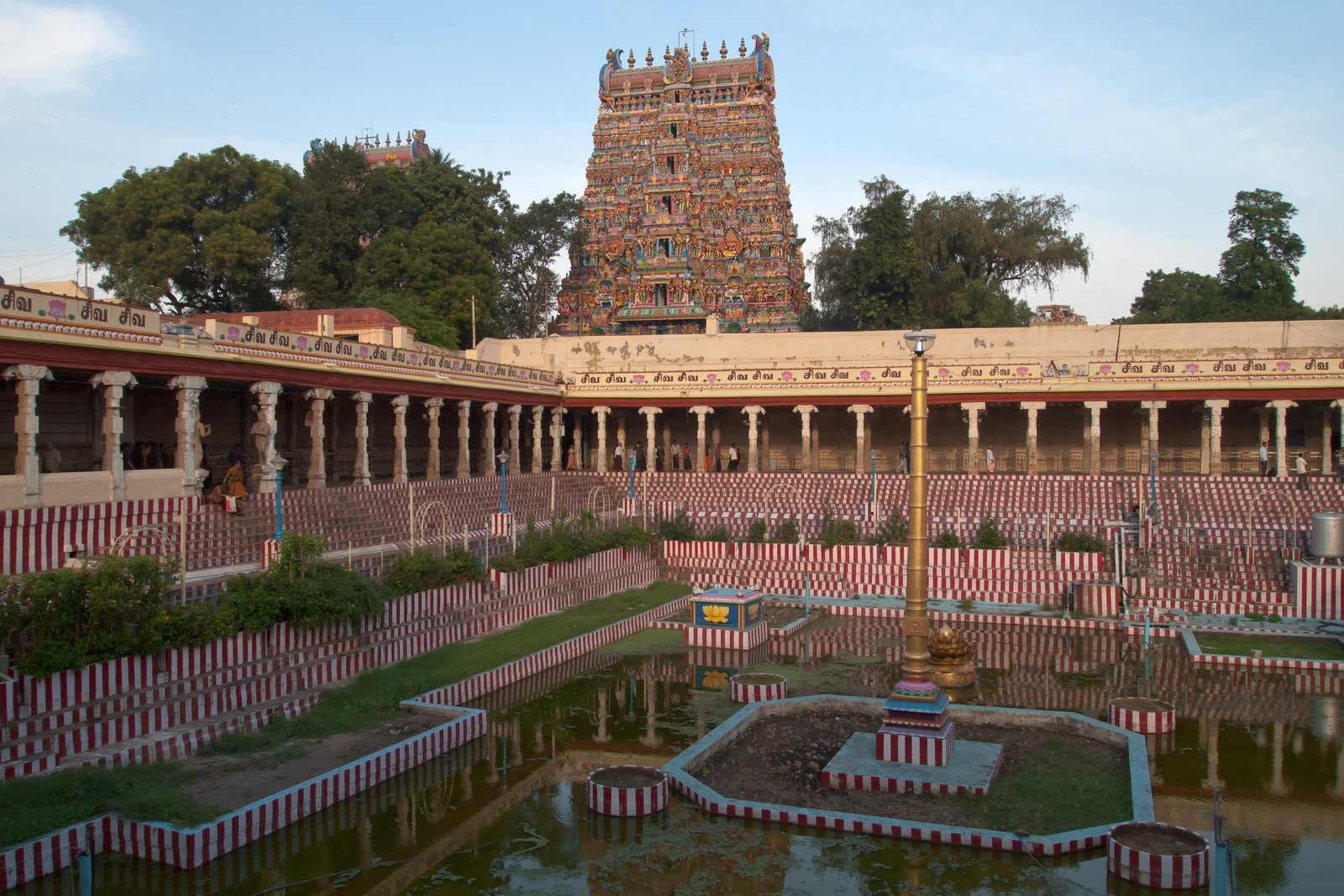 Sculpted gopuram rising above the temple tank and colonnades at Minakshi (Meenakshi) Temple in Madurai, Tamil Nadu.