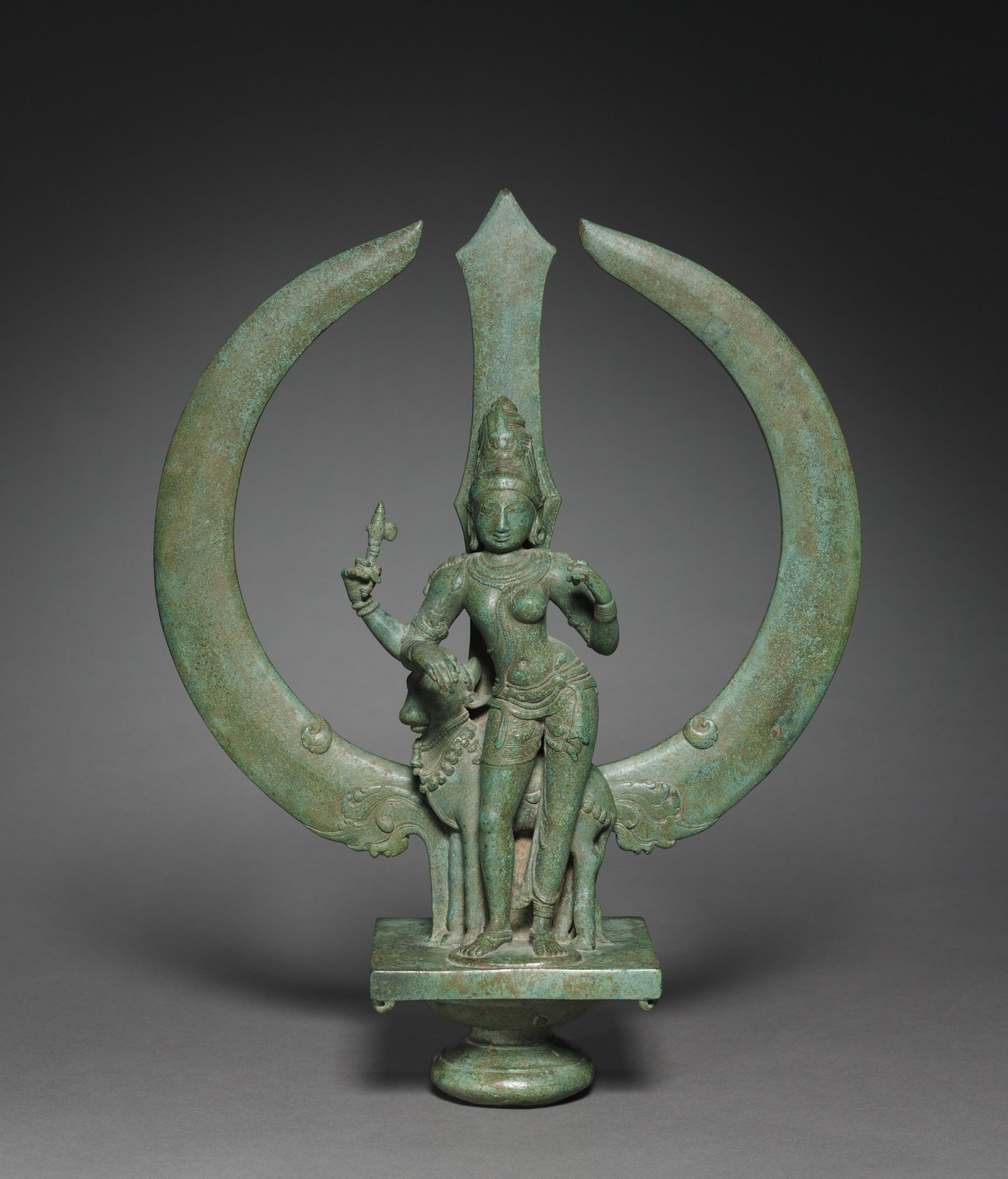 Ardhanarishvara, a composite form combining Shiva and Parvati in one body, within a historic bronze trident.