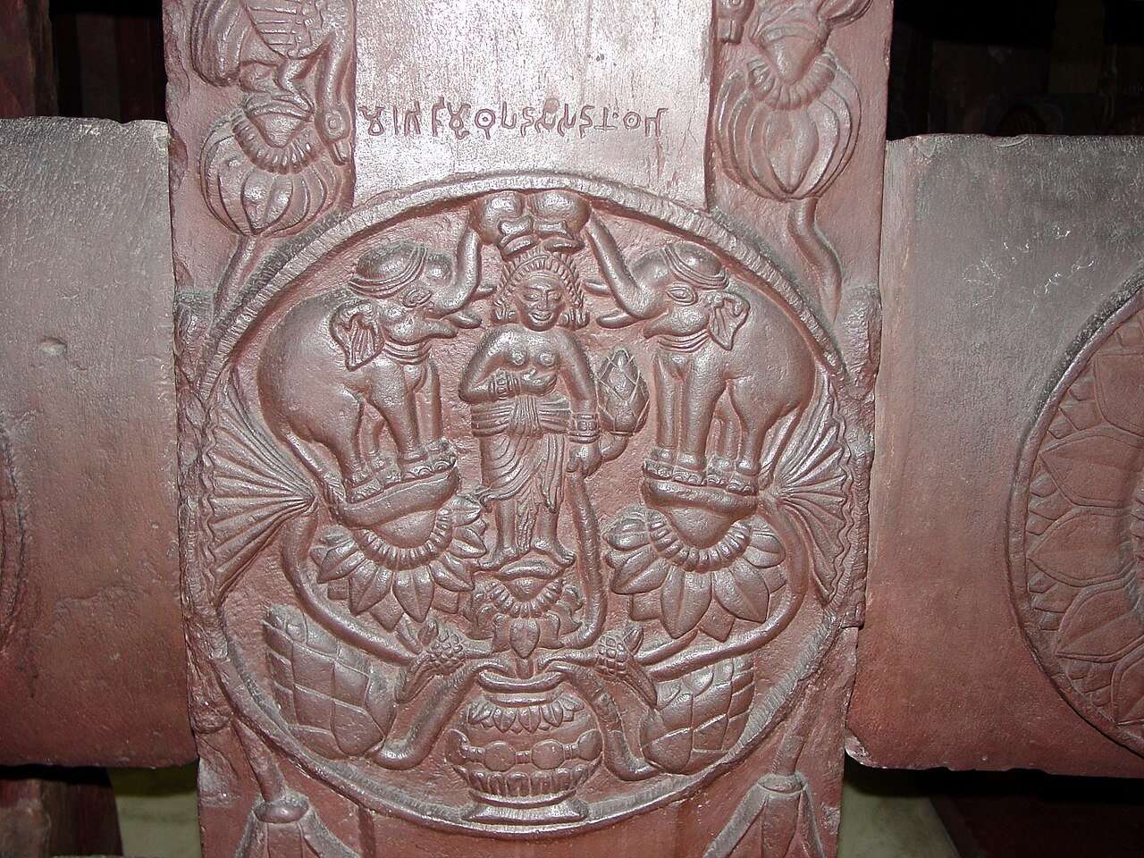 Bharhut stone medallion with Lakshmi standing on a lotus while two elephants lift water vessels above her.